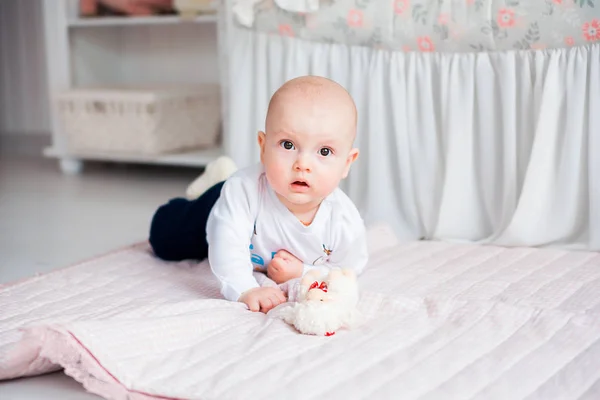 Entzückender kleiner Junge liegt auf dem Boden in ihrem Kinderzimmer und spielt mit Spielzeug — Stockfoto