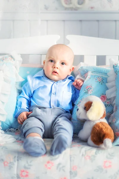 Маленький хлопчик у блакитному одязі сидить на дивані — стокове фото