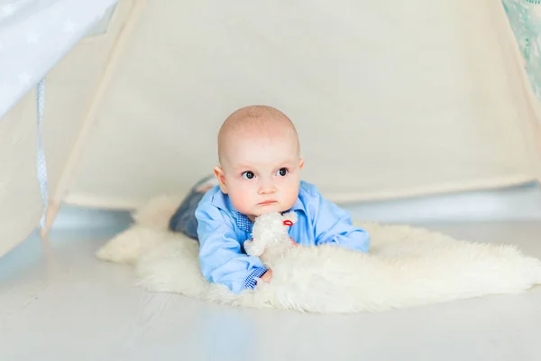 Adorable bebé boyl tendido en el suelo en su guardería debajo de la tienda de campaña —  Fotos de Stock