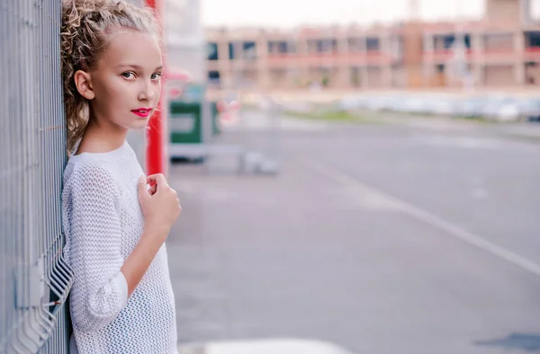 时尚和快乐的青少年女孩摆姿势旁边的建筑和格子 — 图库照片