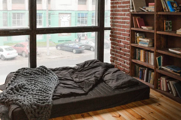 Minsk , Beyaz Rusya - 30 Ocak 2019. Yerde bir yatak ve bir kitaplık ile rahat oda