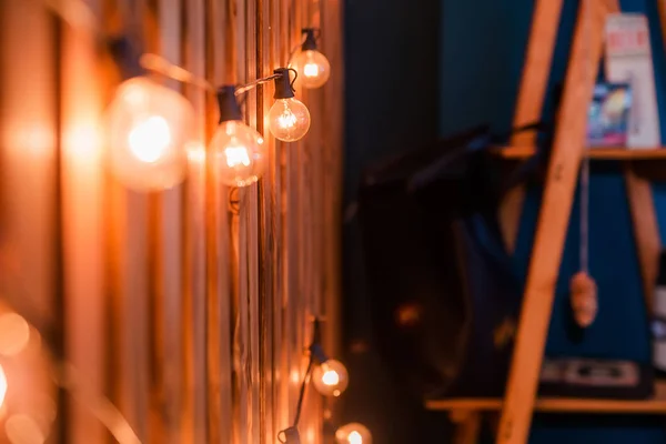 Una guirnalda de bombillas sobre un fondo de madera —  Fotos de Stock