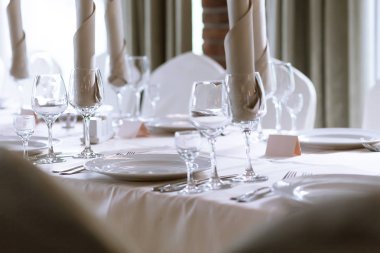 Restoranda zarif masa ayarı. Cam, tabak ve çatal bıçak takımı çeşitli türleri