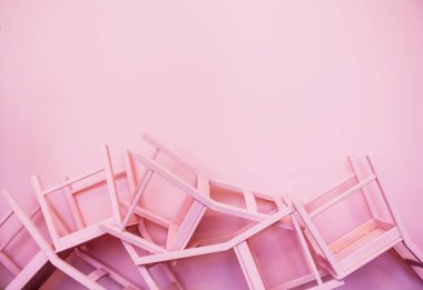 Birçok pembe sandalye baş aşağı pembe bir duvarın arka plan karşı