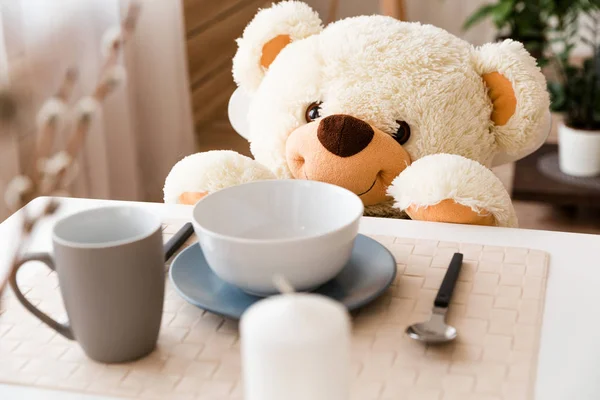 Urso de peluche à mesa. Pequeno-almoço para um urso de brinquedo — Fotografia de Stock