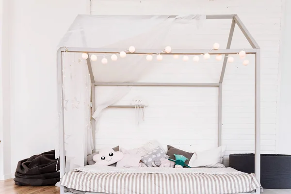 Сучасні дитячі меблі в просторій спальні з прикрасою зірки і гірляндою на ній, і багато подушок — стокове фото