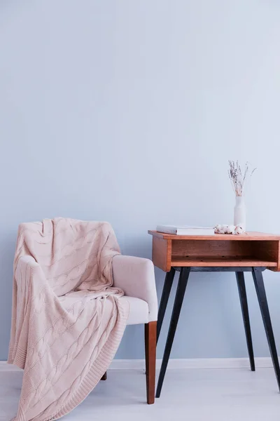 Ekose ve retro masa standı mavi bir duvara karşı koltuk