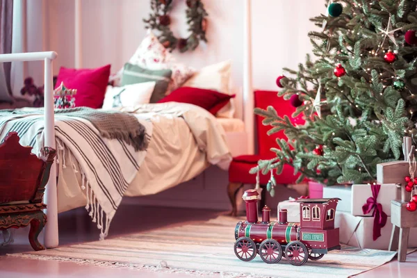 Nieuwe jaren speelgoed locomotief onder de boom in de slaapkamer — Stockfoto