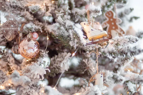 Jouets boule de Noël et patins suspendus sur l'arbre avec de la neige artificielle — Photo