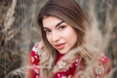 Yüksek çim arasında güzel bir esmer kız Portresi