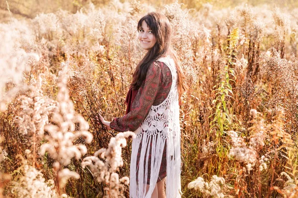 Happy young woman posing among autumn dried flowers — Stock Photo, Image