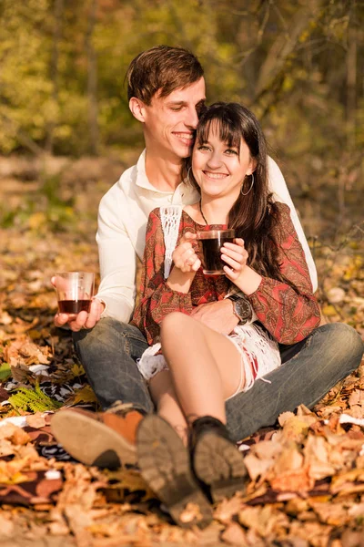 Pareja enamorada - un hombre y una mujer - pasar tiempo juntos en el bosque de otoño, beber té —  Fotos de Stock