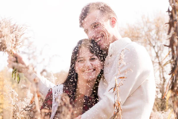 Happy couple - man and woman - posing among autumn yellow dry plants. — Stock Photo, Image