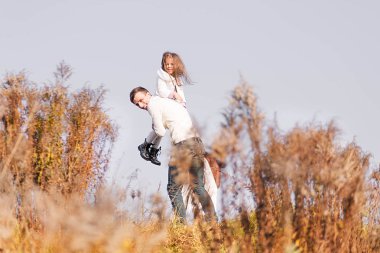 Sonbahar sarı kuru bitkiler arasında poz mutlu baba ve kızı