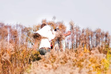 Sonbahar sarı kuru bitkiler arasında poz mutlu baba ve kızı