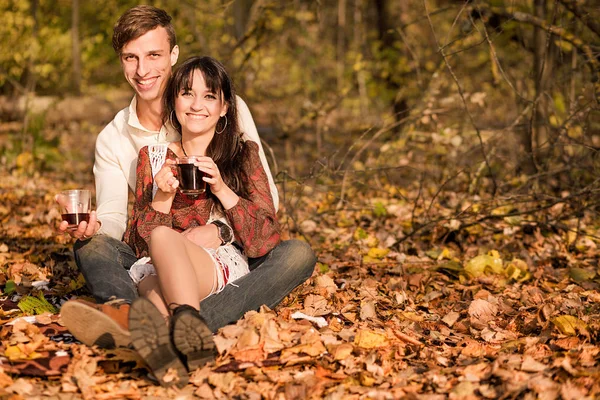 Pareja enamorada - un hombre y una mujer - pasar tiempo juntos en el bosque de otoño, beber té —  Fotos de Stock