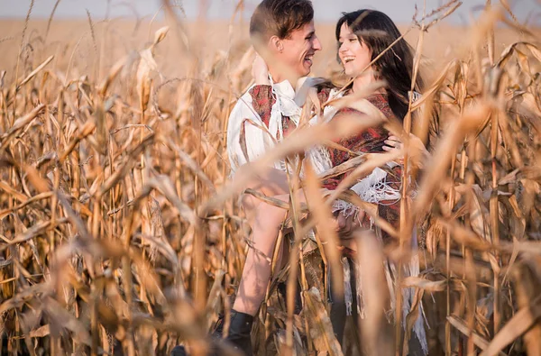 Feliz pareja joven en otoño campo de maíz —  Fotos de Stock