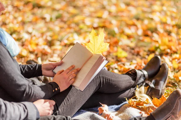 Pareja enamorada - un hombre y una mujer - pasar tiempo juntos en el parque de otoño, leer un libro —  Fotos de Stock