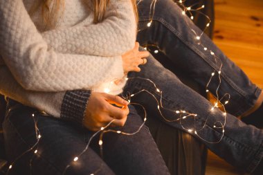 fenerler Yeni Yıl çelenk arasında rahat bir odada sarılmak aşık çift