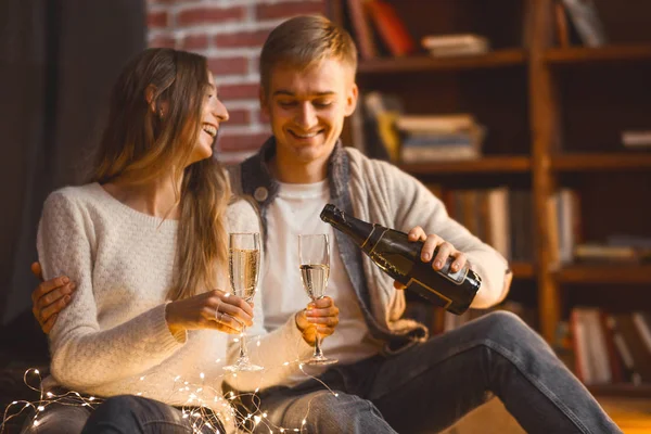 Homme et femme boire du champagne dans une chambre confortable dans la soirée sett — Photo