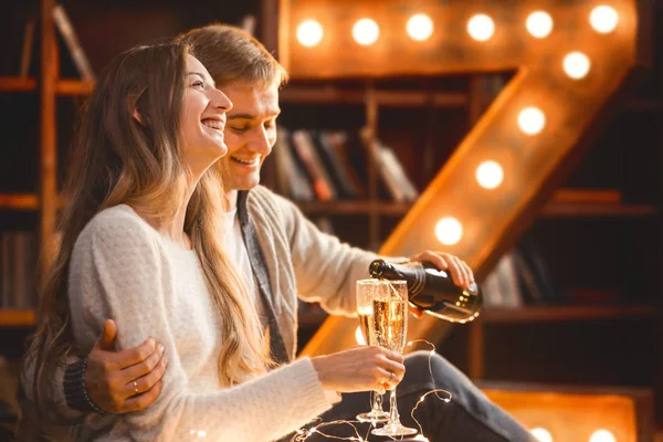 Homme et femme boivent du champagne dans une chambre confortable dans le cadre de la soirée — Photo