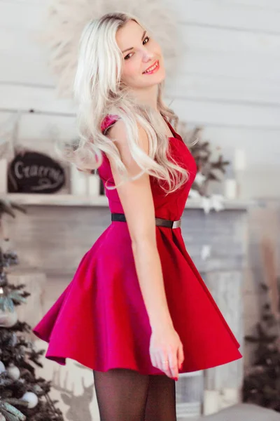 Yeni yıl ağacının yanında kırmızı elbiseli neşeli kız. — Stok fotoğraf