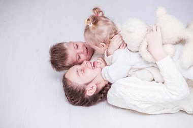 Çocuklar yerde gülüp oynaşıyorlar.