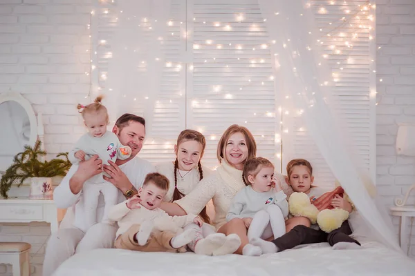 Large family in a New Years interior. Family having fun on the bed.