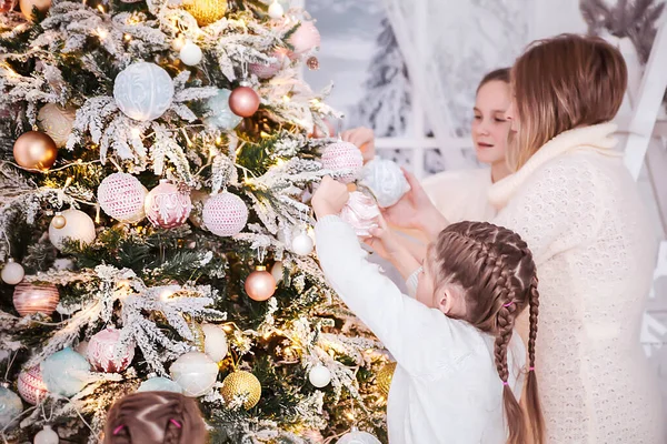 Mãe com suas filhas decora uma árvore de Natal — Fotografia de Stock