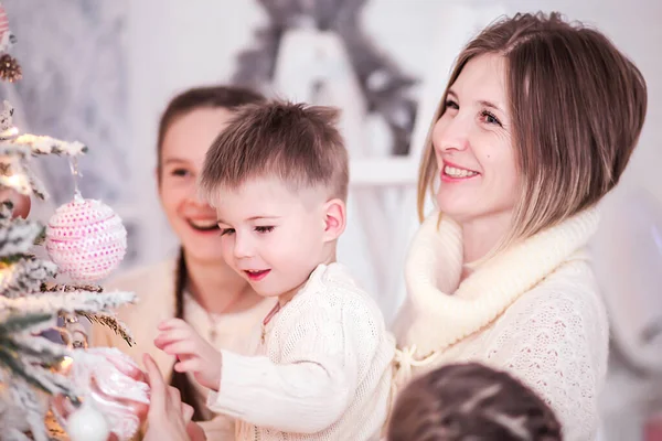 Mãe com seus filhos decora uma árvore de Natal — Fotografia de Stock