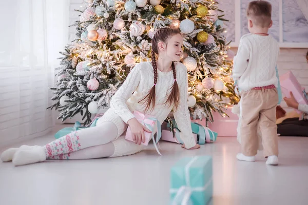 Crianças se divertindo perto da árvore de Natal com presentes . — Fotografia de Stock