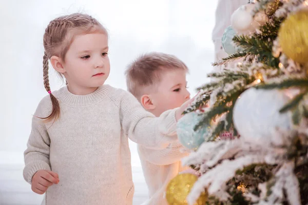 Menina ajuda a decorar uma árvore de Natal — Fotografia de Stock