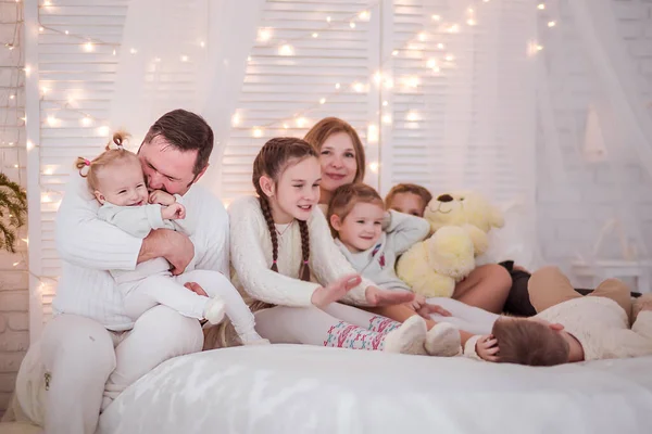 Duża rodzina w noworocznym wnętrzu. Rodzina bawiąca się na łóżku. — Zdjęcie stockowe