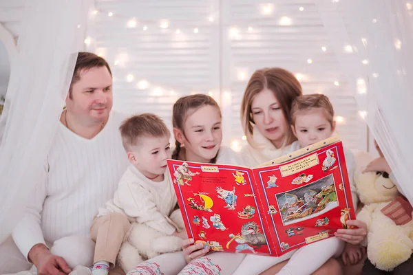 Matka z wieloma dziećmi czyta dzieciom bożonarodzeniowe opowieści — Zdjęcie stockowe