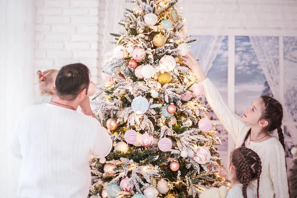 Big beautiful family decorates a Christmas tree
