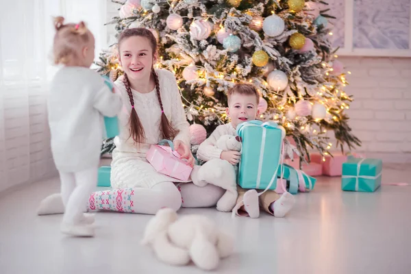 Crianças se divertindo perto da árvore de Natal com presentes . — Fotografia de Stock