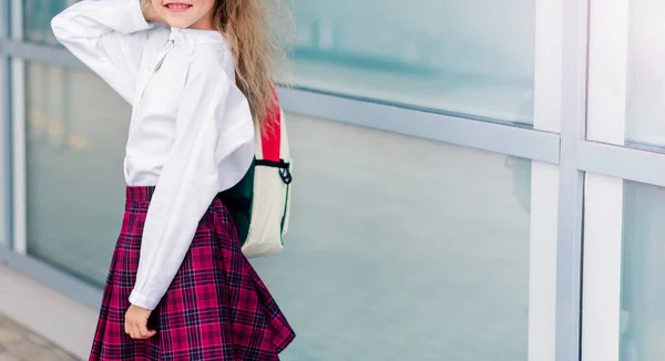 白いブラウスを着た女子高生 背中にリュックを背負った赤いケージのスカート 横写真 — ストック写真