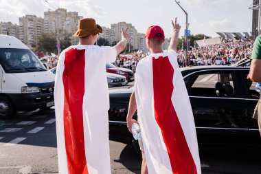 Minsk Belarus - Ağustos 2020: Beyaz Rusya 'da barışçıl protestolar. Belarus 2020 'de başkanlık seçimleri. Bir adam beyaz-kırmızı-beyaz bayraklara asıldı ve sırtı kameraya dönük durdu. Yatay fotoğraf