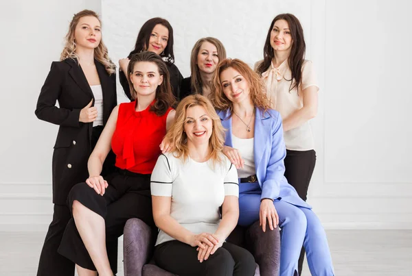 Happy women work team employees group looking at camera posing in studio, smiling women company staff workers, workforce members, business people managers standing together, portrait. Horizontal photo