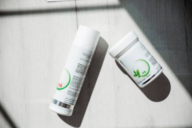 Minsk, Belarus - 25 Haziran 2019. İsrail 'in önde gelen kozmetik cilt bakım ürünleri üreticisinin fotoğrafı. Onmacabim. Yukarıdan bak. Güneş ışınlarında iki kavanoz kozmetik yatıyor. Yatay fotoğraf