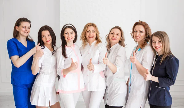 Belas Jovens Médicas Uniforme Branco Posando Contra Fundo Uma Parede — Fotografia de Stock