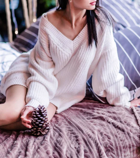 Brunette Mädchen Sitzt Auf Einem Weichen Bett Einem Weißen Pullover — Stockfoto