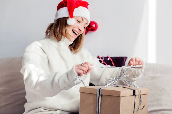 Una Joven Con Suéter Blanco Sombrero Papá Noel Abre Regalo —  Fotos de Stock