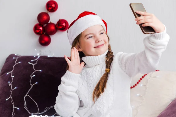 Una Niña Con Suéter Blanco Sombrero Papá Noel Mira Teléfono —  Fotos de Stock