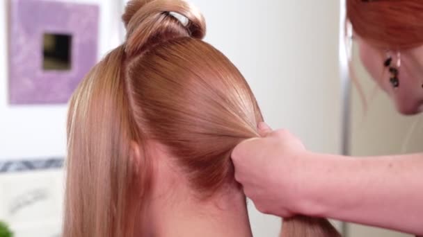 Haarstylist doet kapsel voor lang blond haar — Stockvideo