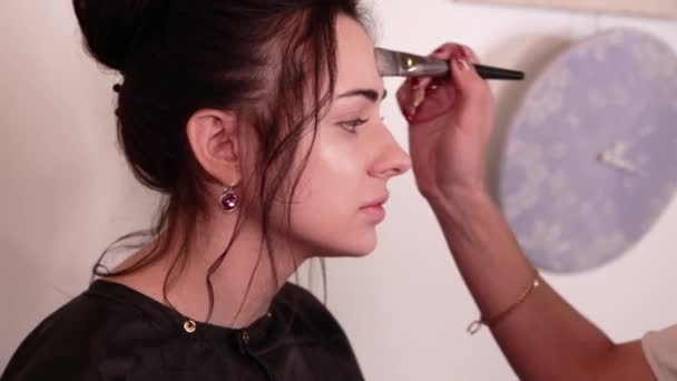 Στυλίστρια μακιγιέρ κάνει μακιγιάζ σε μια μελαχρινή κοπέλα — Αρχείο Βίντεο