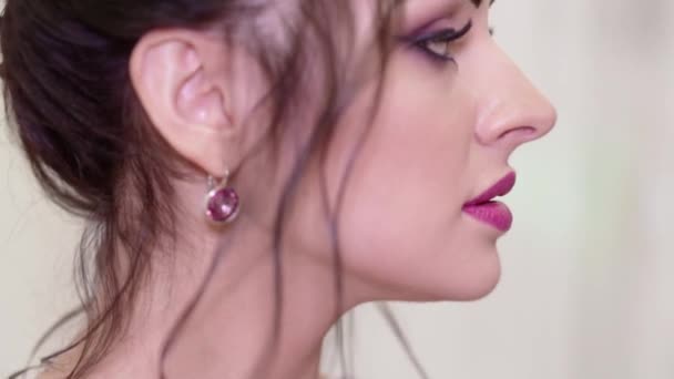 Brunette fille avec beau maquillage et coiffure posant devant la caméra dans une robe violette — Video