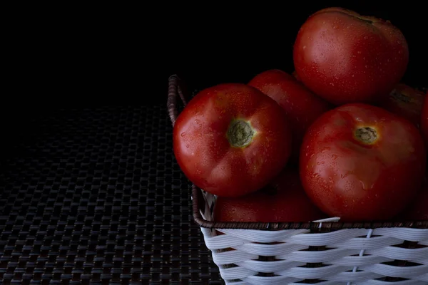 Verse Tomaten Een Plaat Een Donkere Achtergrond Een Mand Vol — Stockfoto