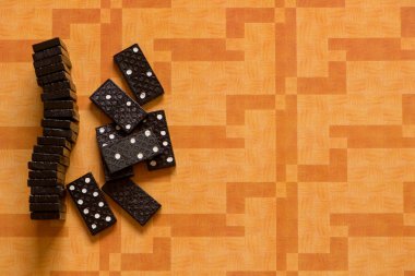 Turuncu bir arka plan üzerinde küçük siyah Domino