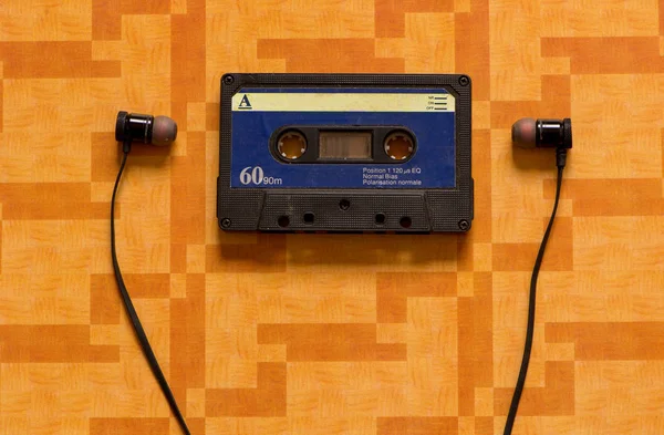 Ein Kassettenband Mit Kopfhörern Auf Orangefarbenem Hintergrund — Stockfoto